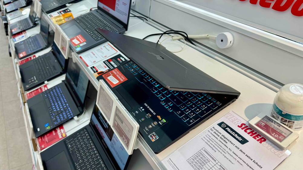 Der Gaming-Laptop bis 1.000 Euro im Test mit halb zugeklapptem Display von der Seite auf einem Verkaufsregal.