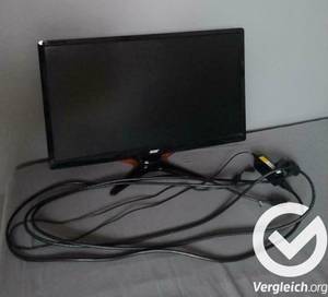 Ein Monitor und das dazugehörige Stromkabel liegen nebeneinander.