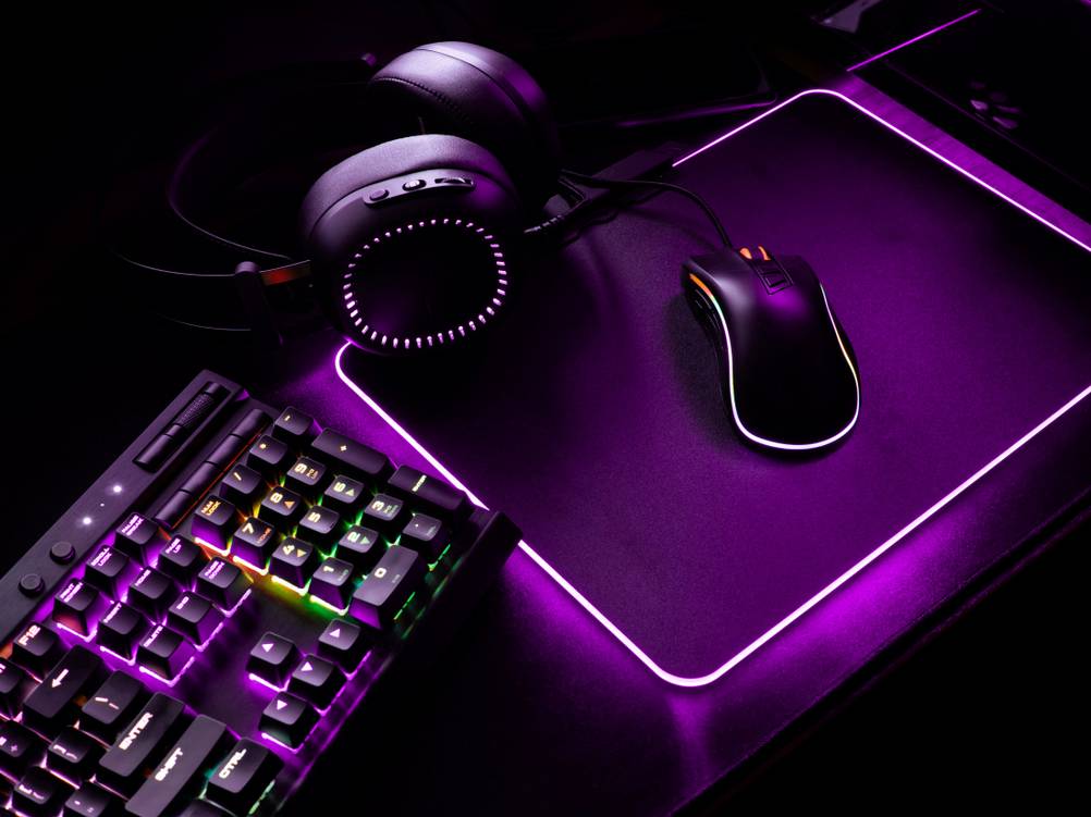 Gaming-Mousepads im Test: Ein typisches Gaming-Setup mit beleuchteter Maus, Tastatur, Headset und XXL-Mousepad.
