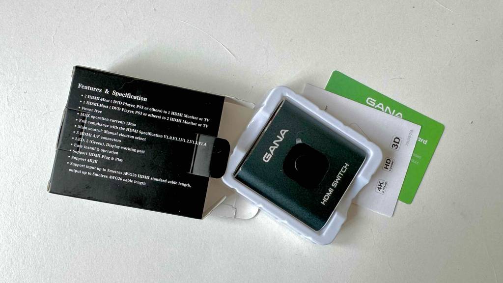 HDMI-Splitter-Test: Auf der Rückseite der Originalverpackung, die neben dem Gerät liegt, stehen Informationen zur Ausstattung und Verwendung.