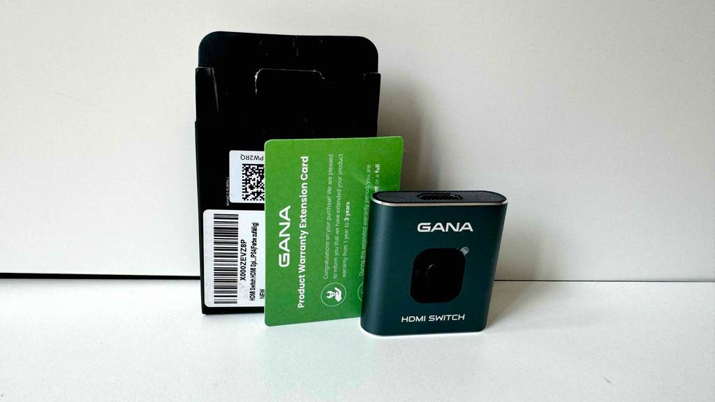 HDMI-Splitter im Test: Ein Gerät steht samt Verpackung und Garantiekärtchen in einem weißen Regal.