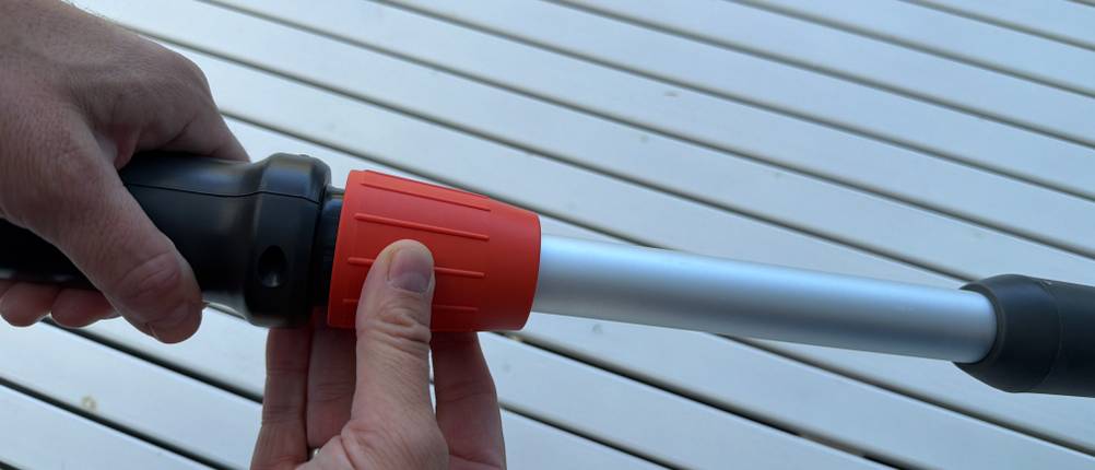 Eine Hand schraubt die Verlängerung der Gardena 430933 auf.