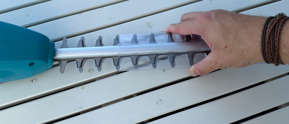 Eine Hand zieht eine Abdeckung von der Gardena 430933.