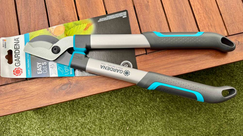 Auf einem Holzboden befindet sich die Gardena-Astschere im Test.