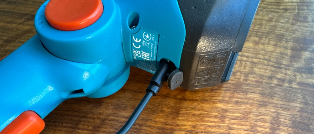 Die Gardena ComfortCut Li 9888-20 hängt an einem Ladekabel.