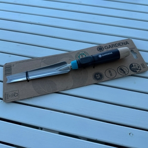 Der Gardena-EcoLine-Unkrautstecher (17702-20) liegt eingepackt auf einem Tisch.