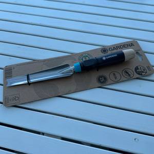 Der Gardena-EcoLine-Unkrautstecher (17702-20) liegt eingepackt auf einem Tisch.