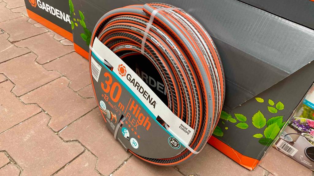 Ein getesteter flexibler Gartenschlauch, mit 30 m Länge und 13 mm Durchmesser, steht vor einem Karton der Marke Gardena.