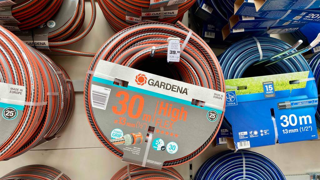Inmitten mehrerer Gartenschläuche hängt ein getesteter flexibler Gartenschlauch, mit 30 m Länge und 13 mm Durchmesser.
