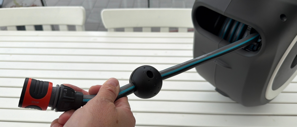 Eine Hand zieht den Schlauch aus der Gardena RollUp M 18612-20