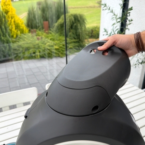 Eine Hand hält die Halterung und Abdeckung der Halterung an die Gardena RollUp M 18612-20