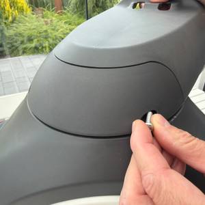 Eine Hand schraubt eine Schraube in die Halterung der Gardena RollUp M 18612-20