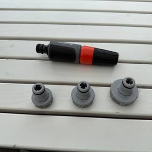 Die Spitze der Gardena RollUp M 18612-20 liegt neben drei verschiedenen Anschlüssen auf einem Tisch