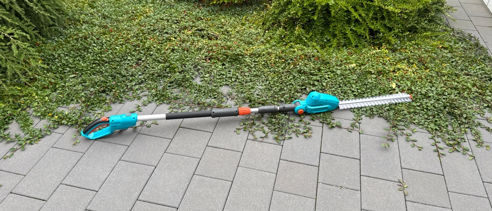 Die Gardena THS 42/18V liegt auf einem gepflasterten Boden