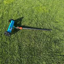 Der Gardena-Vertikutier-Boy 3395-20 liegt auf einer Grasfläche.