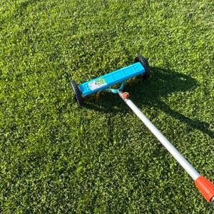 Der Gardena-Vertikutier-Boy 3395-20 wird über eine Grasfläche gezogen.