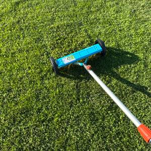 Der Gardena-Vertikutier-Boy 3395-20 wird über eine Grasfläche gezogen.