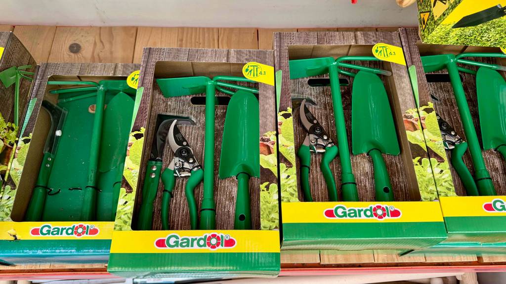 Mehrere Gartenwerkzeug-Sets im Test liegen auf einem Ausstellungsregal im Verkauf.