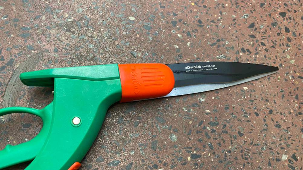 Grasscheren im Test: Detailansicht der Schneidefläche einer Schere, die auf dem Boden liegt.