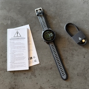 Der Lieferumfang der Garmin Forerunner 165 liegt auf einem Tisch