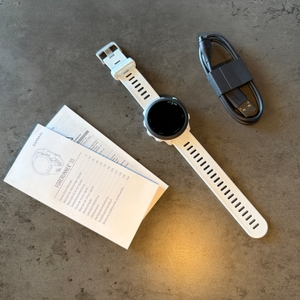 Der Lieferumfang der Garmin Forerunner 55 liegt auf einem Tisch