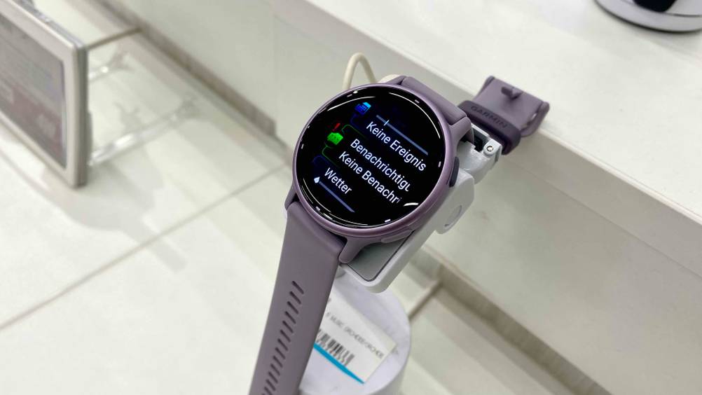 Im Test: Eine Garmin-Smartwatch für Damen von schräg oben auf einem Ständer mit eingeblendeten Informationen auf dem Display.