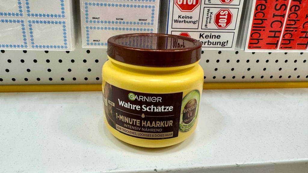 Ein Tiegel Garnier-Haarkur steh tzum testen auf einem weißen Regalbrett vor Aufklebern.