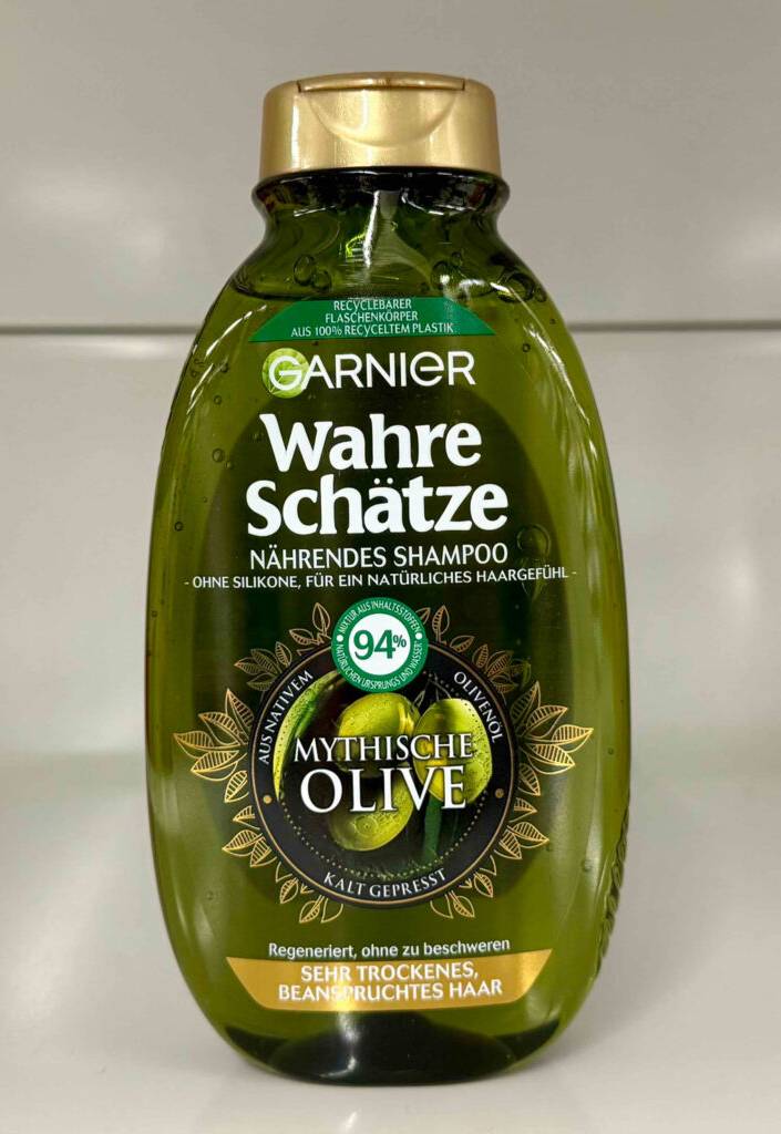 Olivenöl-Shampoo-Test: Eine grün-transparente Kunststoffflasche mit goldenem Spenderverschluss steht vor einem weißen Hintergrund.