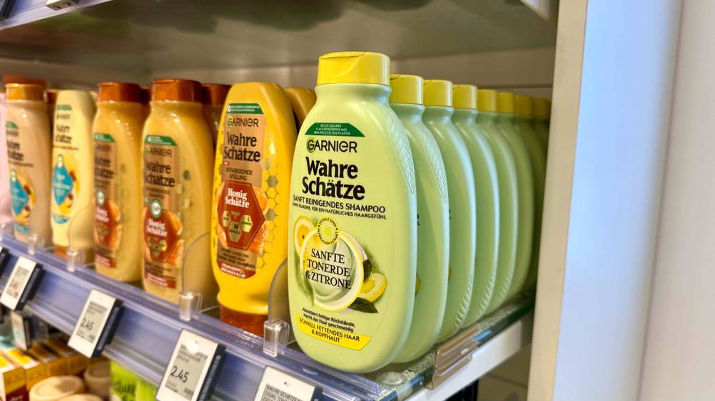 Garnier-Shampoo im Test: Mehrere Flaschen von schräg seitlich in einem Regal neben anderen Produkten.