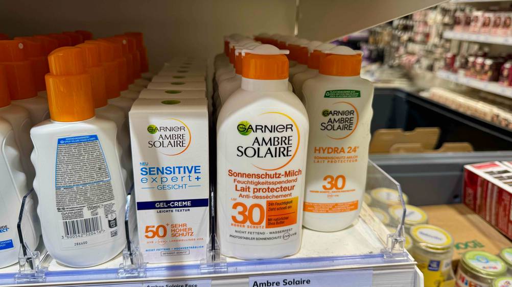 Mehrere Flaschen der Garnier-Sonnencreme im Test stehen neben anderen Produkten in einem Verkaufsregal.