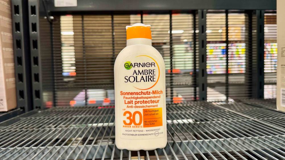 Eine Flasche der getesteten Garnier-Sonnencreme steht auf einem Gitter.