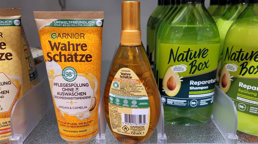 Haaröl-Test: eine goldfarbene Flasche Garnier Wahre Schätze steht mit der Produktbeschreibung zur Kamera zwischen anderen Garnier Haarpflegeprodukten.