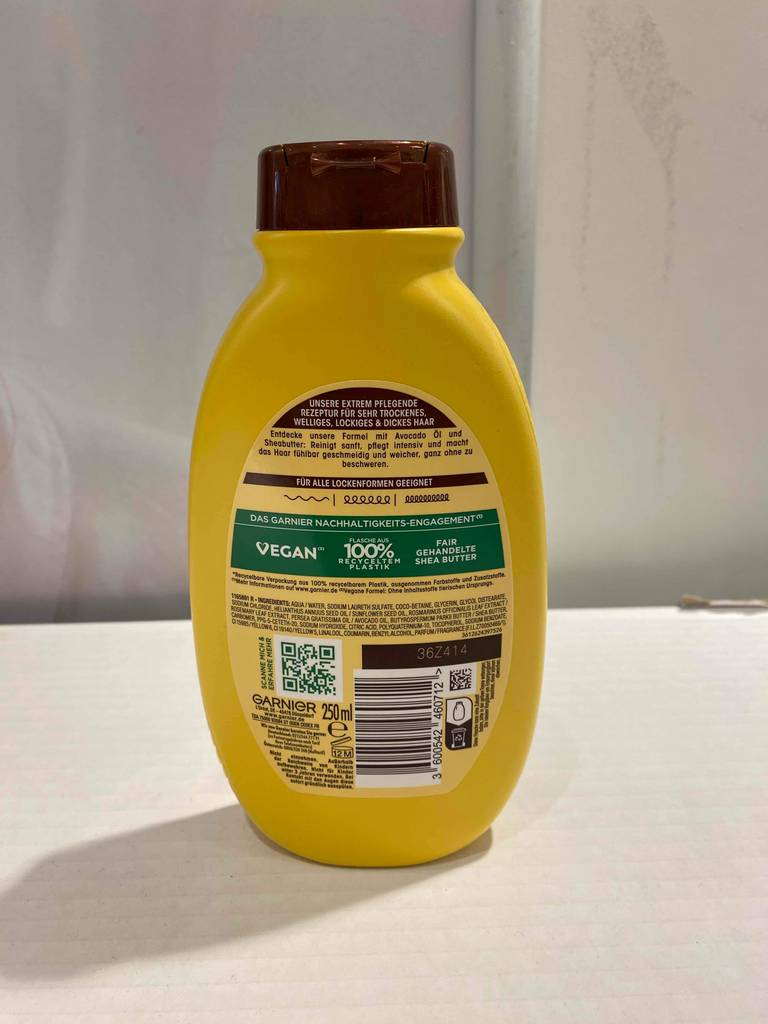 Im Test: Eine Flasche Wahre Schätze-Shampoo steht mit der Rückseite nach vorn auf einem weißen Regalbrett.