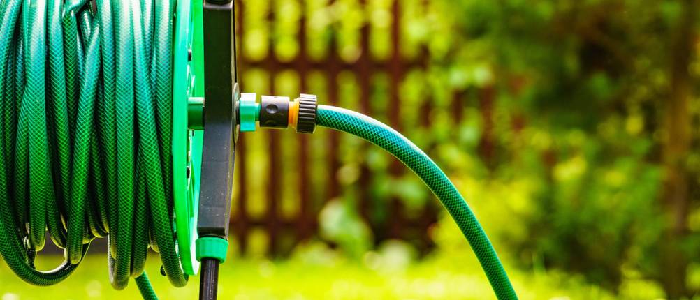 Getestete Gartenbewässerung: Aufgerollter Schlauch im Garten.