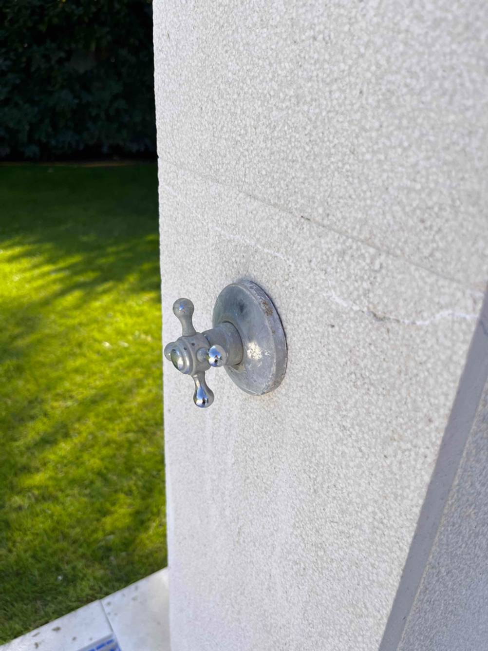 Gartendusche-Test: Nahaufnahme eines auf der Mauer liegenden Drehventils.