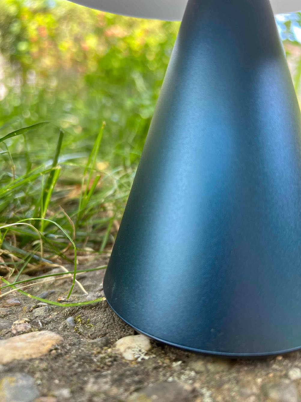 Gartenleuchte getestet: Nahaufnahme des Fußes der Lampe auf Steinen im Garten.