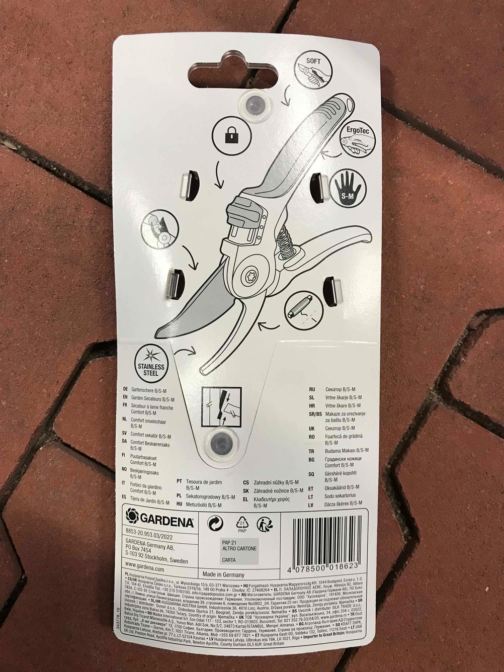 Rückseite der Verpackung einer getesteten Gartenschere auf einer Steinfläche.