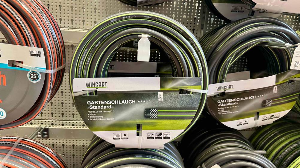 Mehrere der getesteten Gartenschläuche 30m hängen in einem Verkaufsregal.