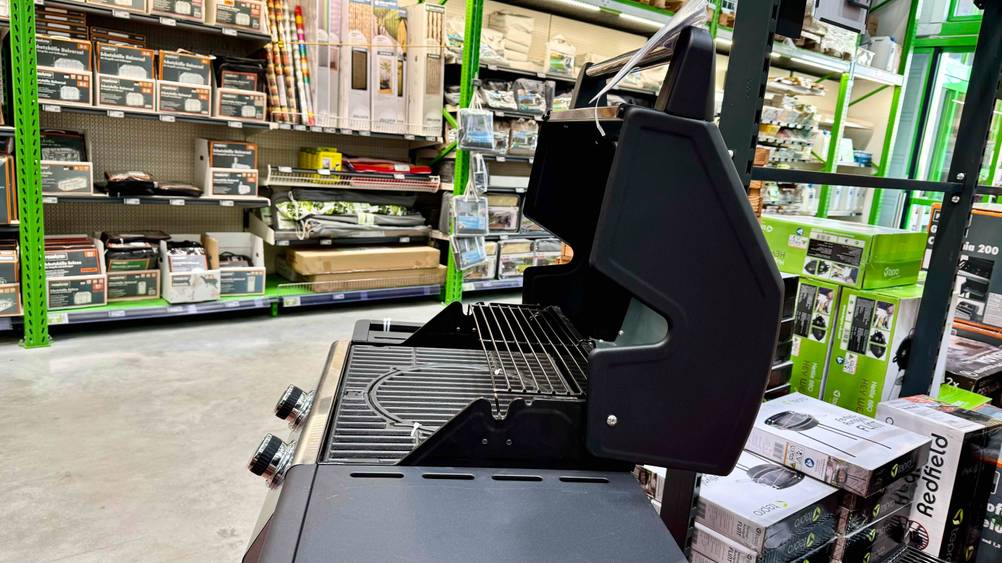 Der getestete Gasgrill bis 400 Euro mit offenem Deckel von der Seite in einem Verkaufsladen.