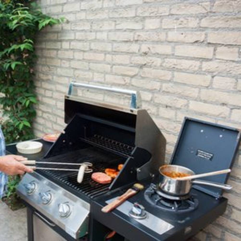 gasgrill mit seitenbrenner wird benutzt