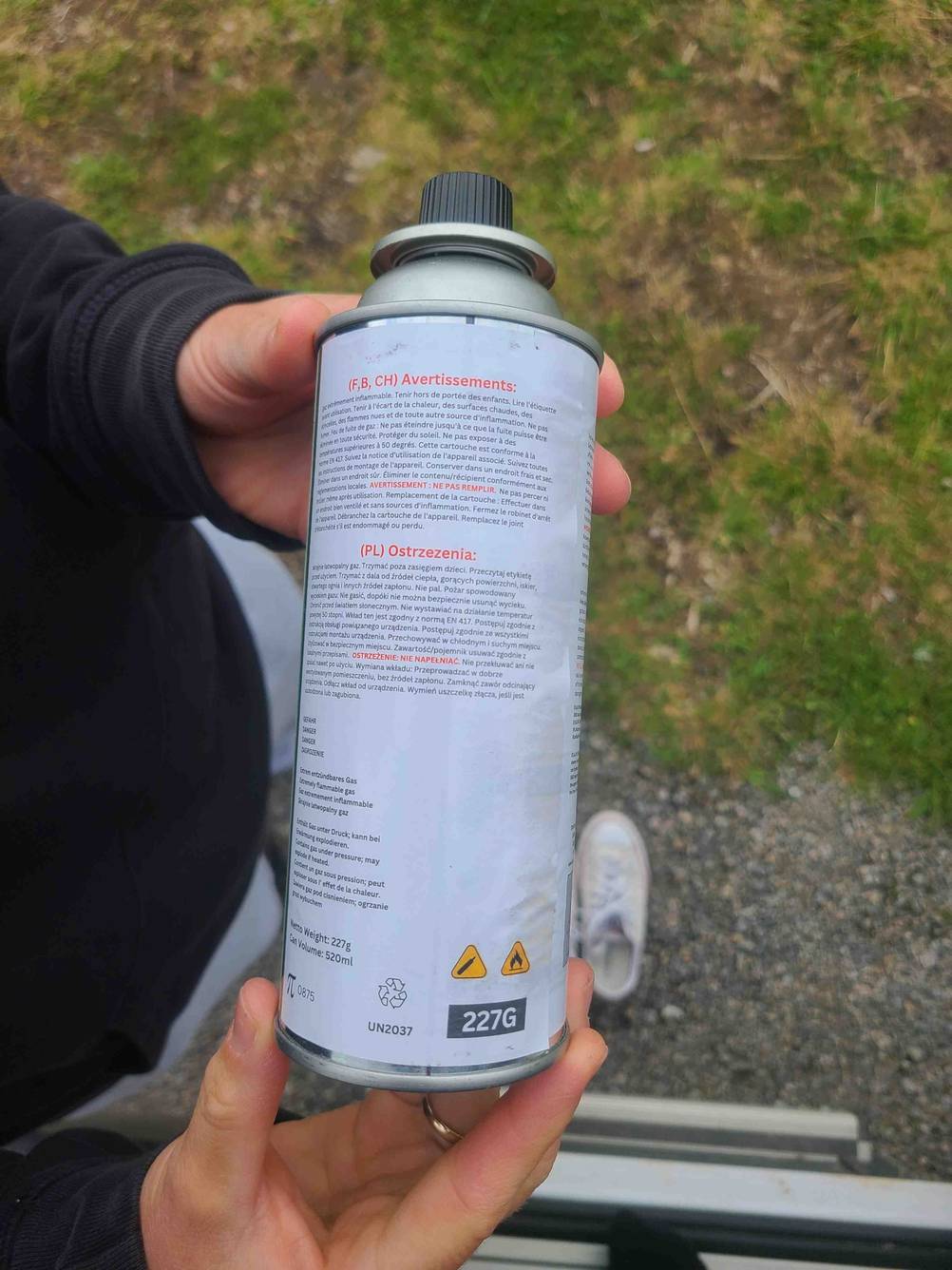 Die Rückseite der getesteten Gaskartusche von zwei Händen gehalten.