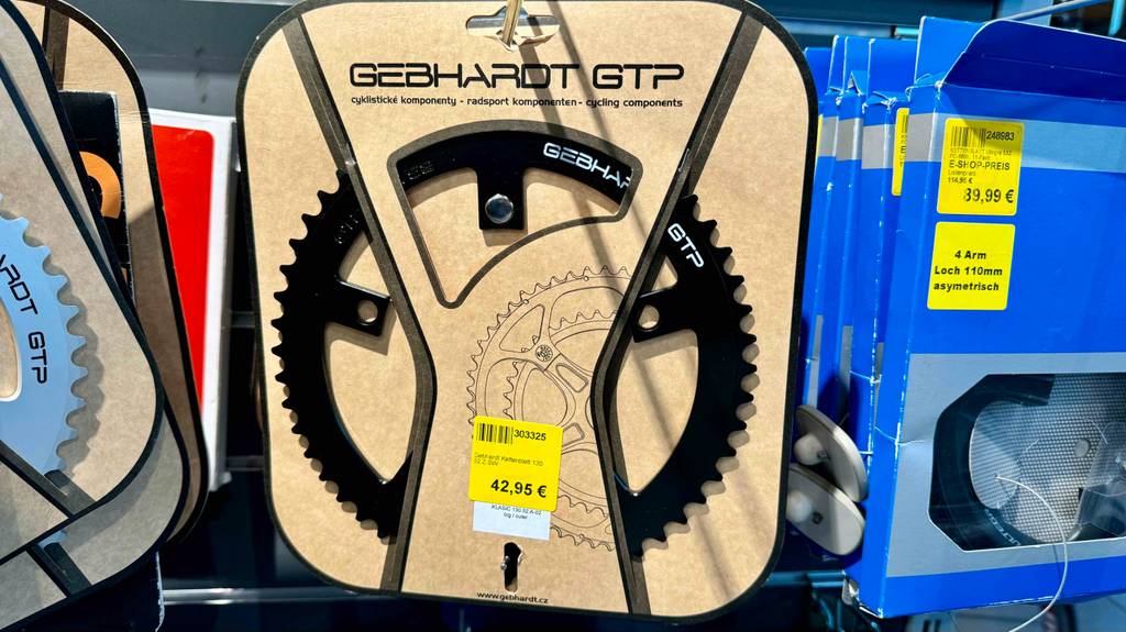Kettenblätter im Test: Nahaufnahme eines Modells von Gebhardt in seiner Verpackung inklusive Preisetikett, das neben weiteren Kettenblättern an einem Verkaufsstand hängt.