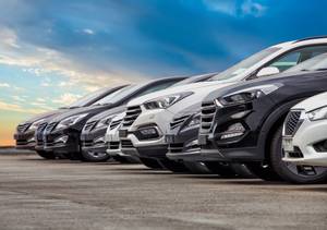 Gebrauchtwagen-kaufen-Test: Mehrere Autos stehen nebeneinander, während im Hintergrund die Sonne untergeht.