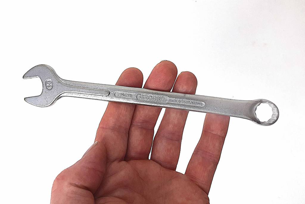 Eine Hand hält einen Schraubenschlüssel zum testen.