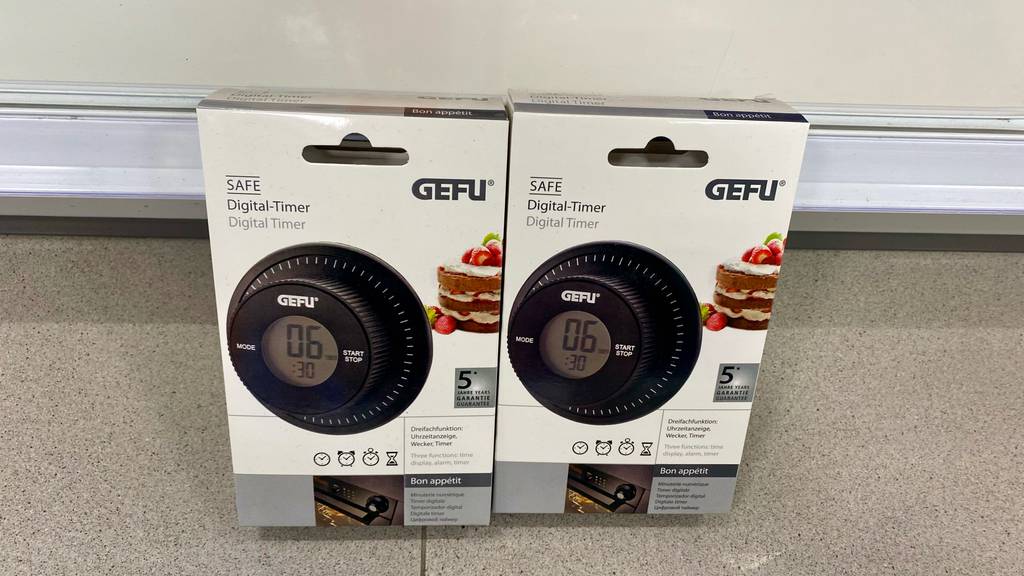 Getestete digitale Timer von Gefu befinden sich in zwei Original-Verpackungen auf dem Boden.