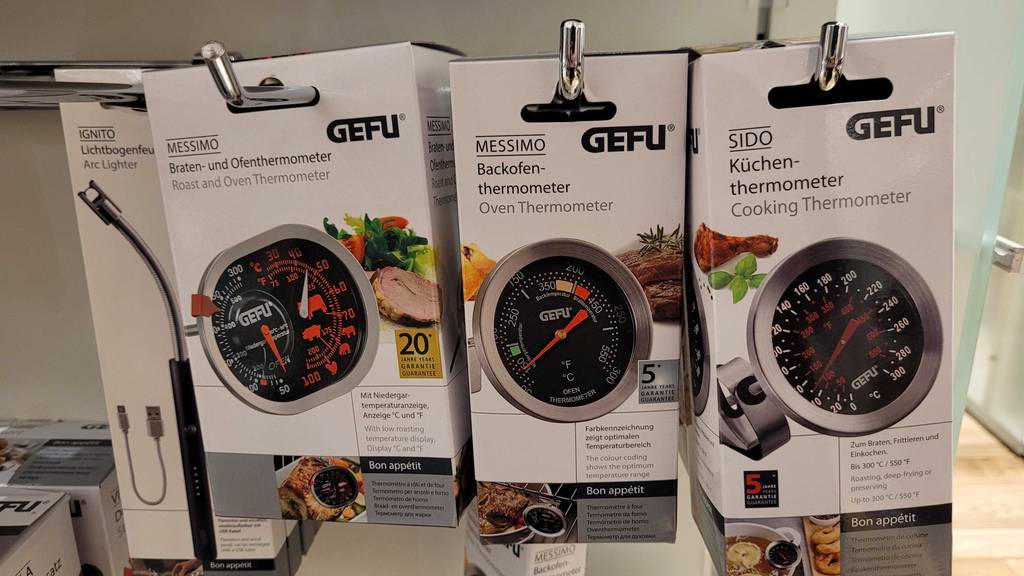 Mehrere verpackte Backofenthermometer hängen zum testen neben- und hintereinander in einem Verkaufsregal.