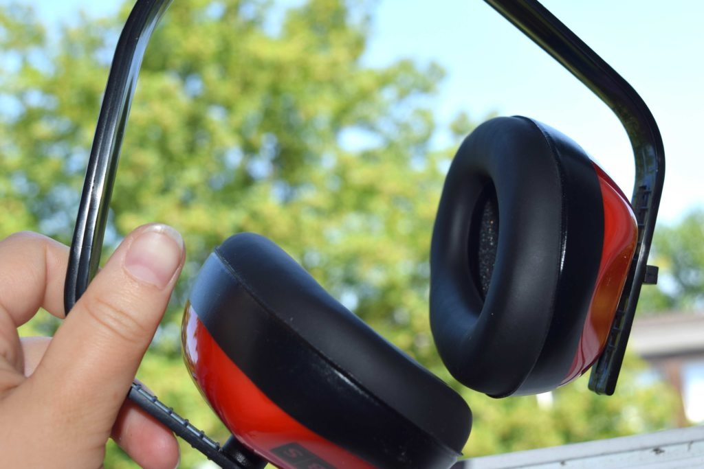 Eine Hand hält den SBS-Gehörschutz.