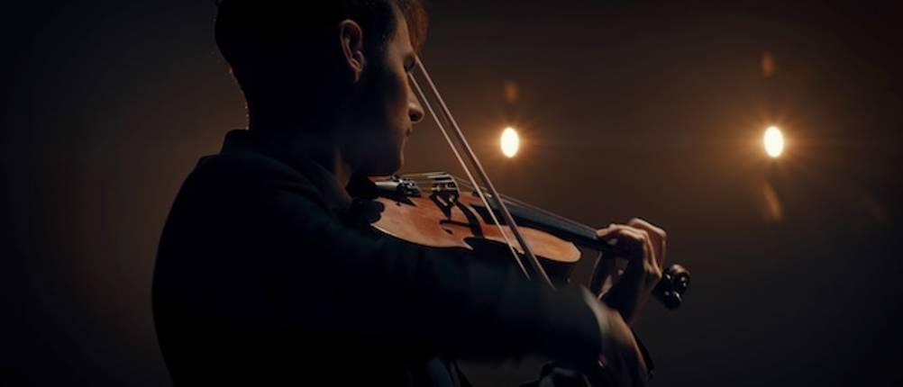 Geigenbogen wird von einem Mann beim Spielen einer Violine getestet.