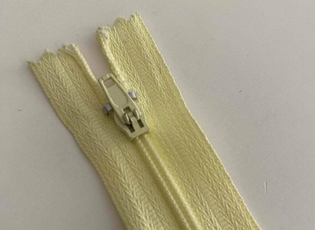 Reißverschlüsse im Test: Detailansicht des Läufers an einem gelben Reißverschluss.