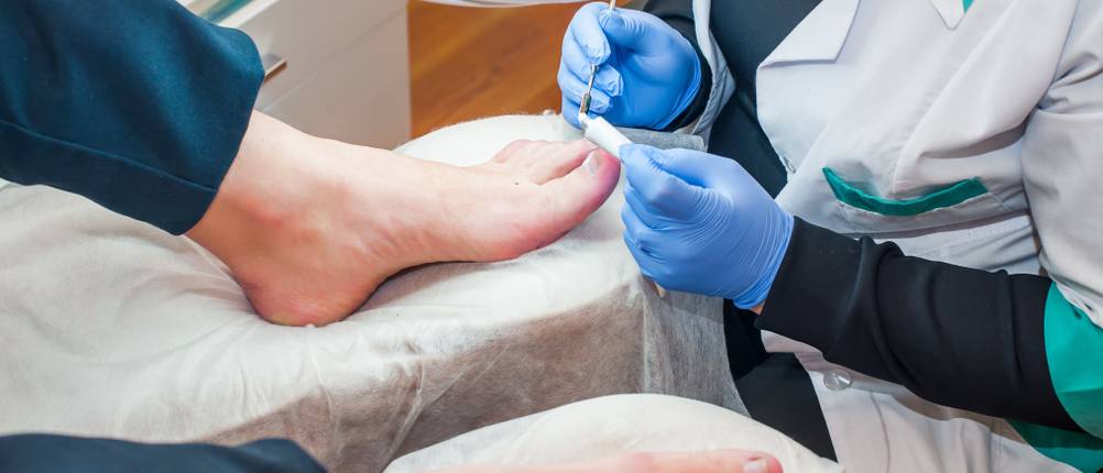 Podology treatment. Podiatrist treating toenail fungus. Doctor removes calluses, corns and treats ingrown nail. Hardware manicure. Health, body care concept. Selective focus.